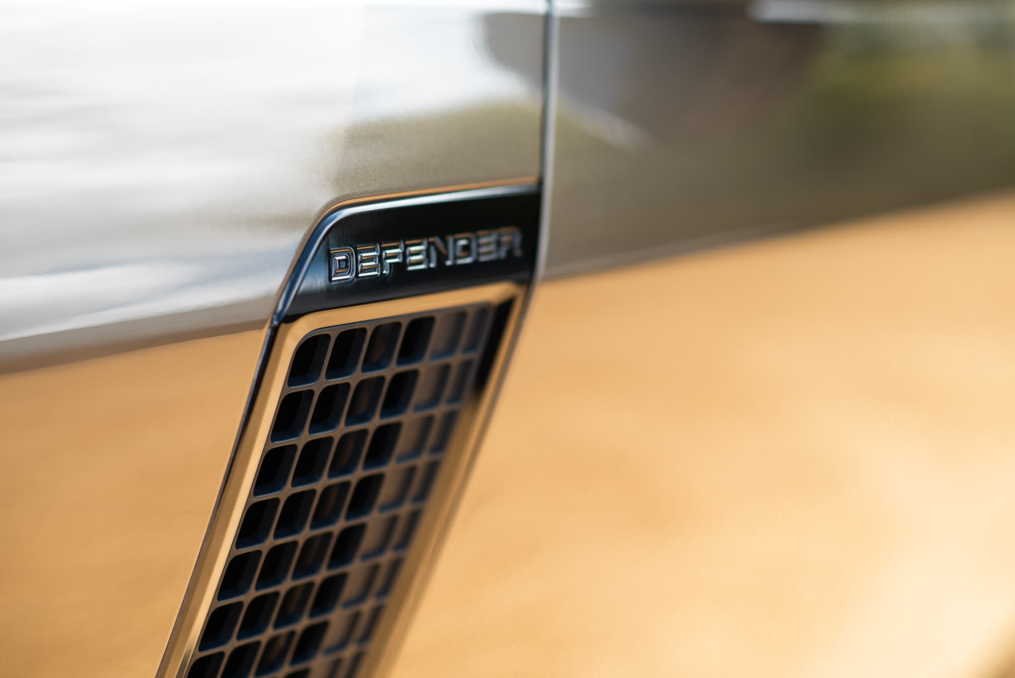 Detail of the Defender badge and side vent on a Land Rover Defender