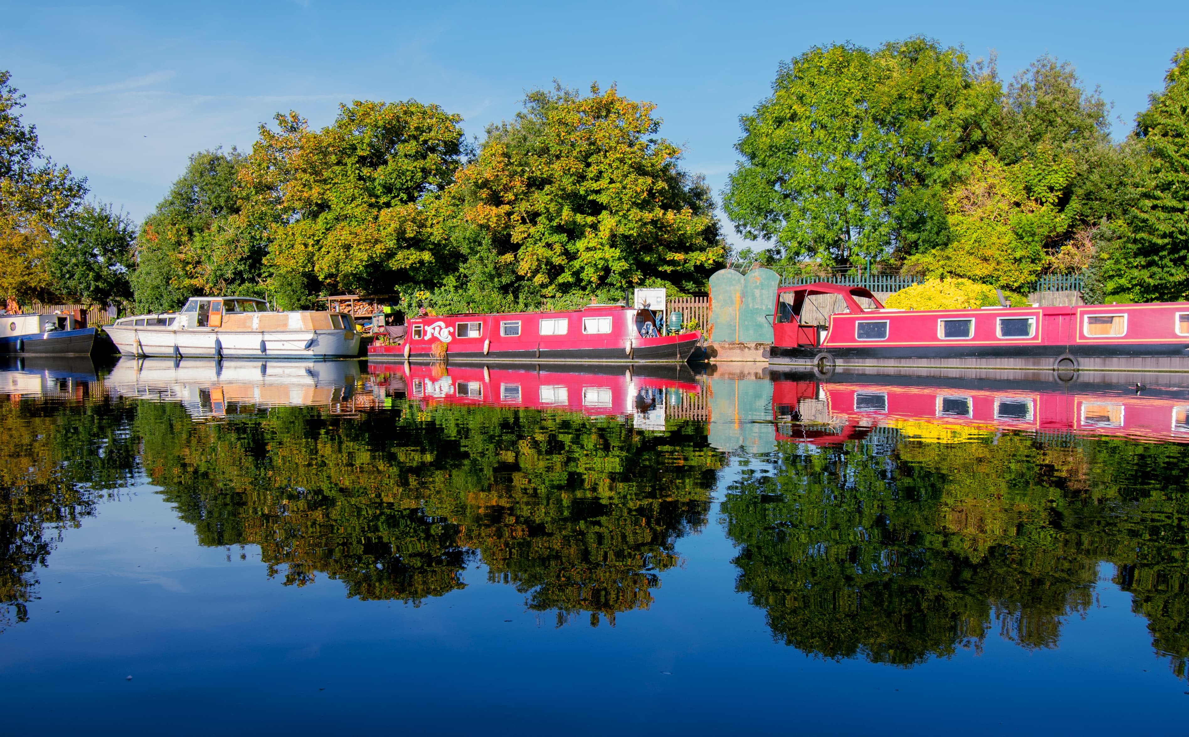 Barges reflecting with riverside trees in a Surrey river scene