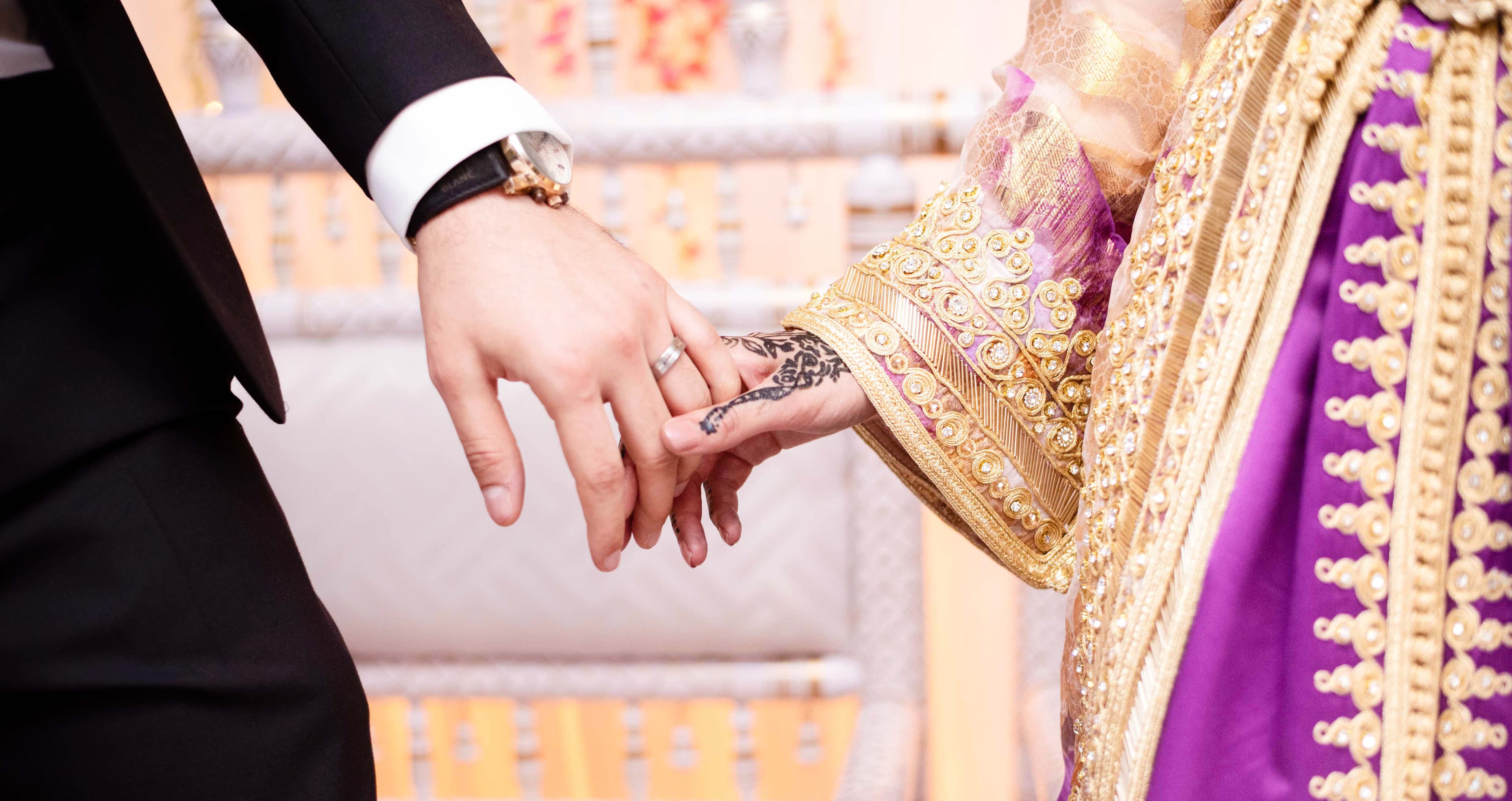 Bride and groom holding hands secretly