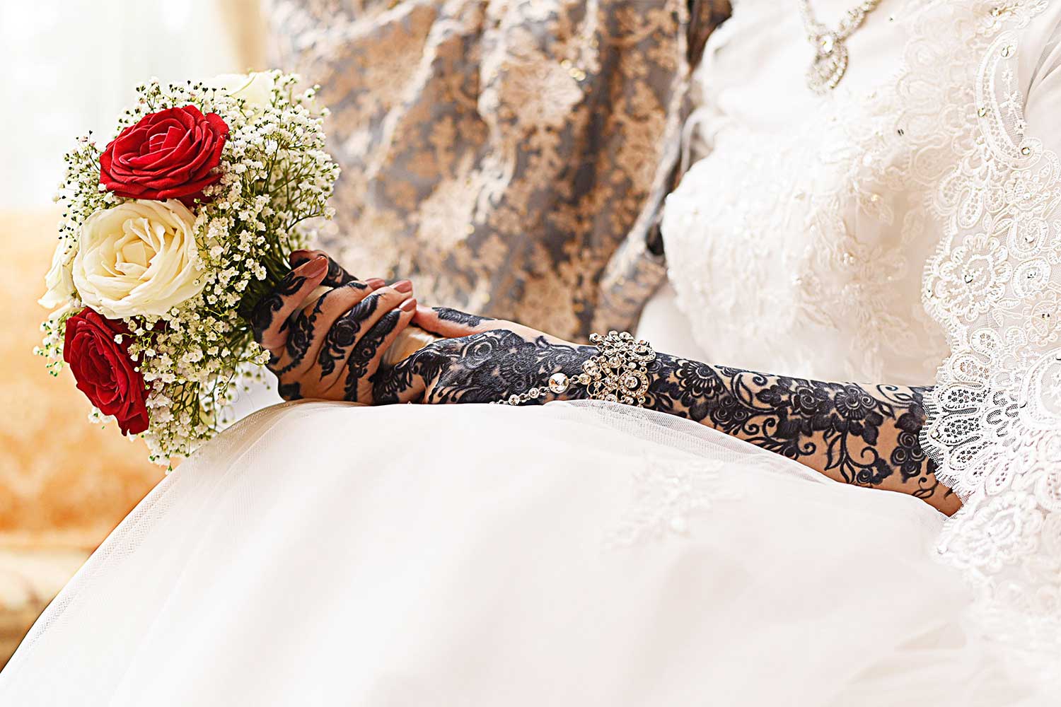 Bride holding colorful bouquet while seated