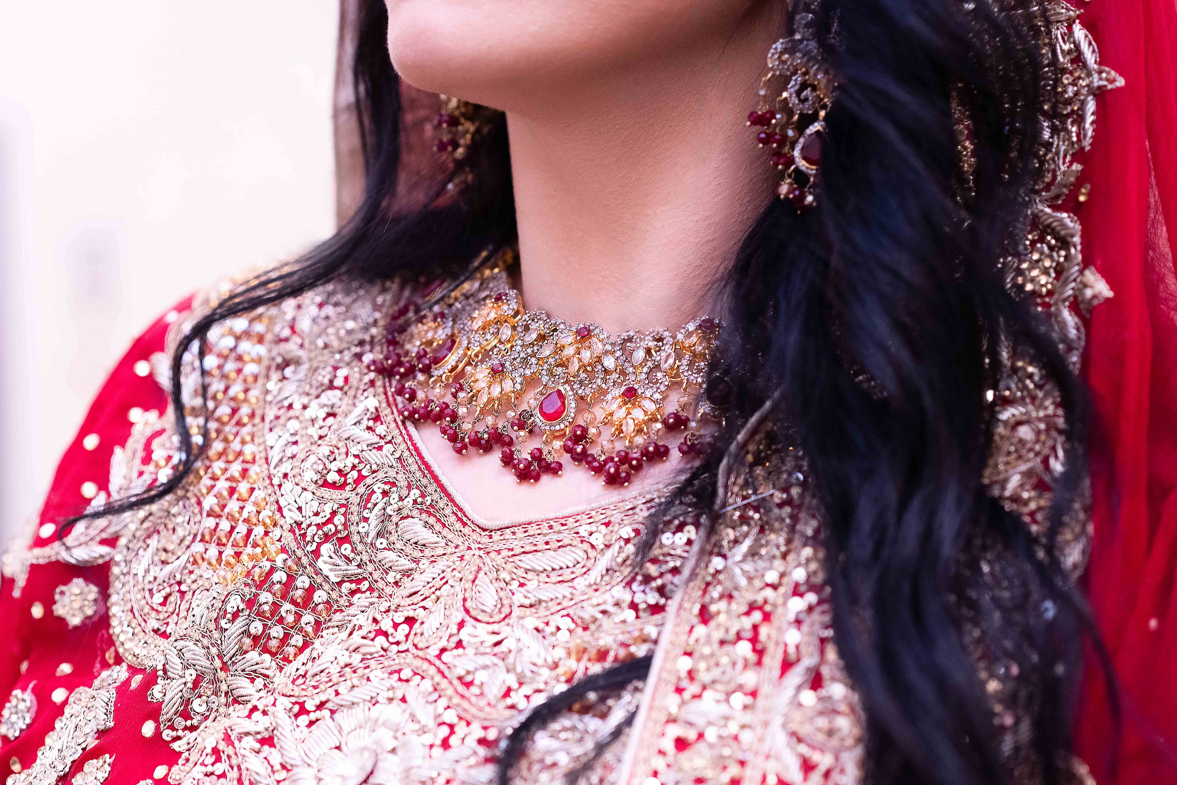 Close-up of a bride's neck adorned with a ruby necklace