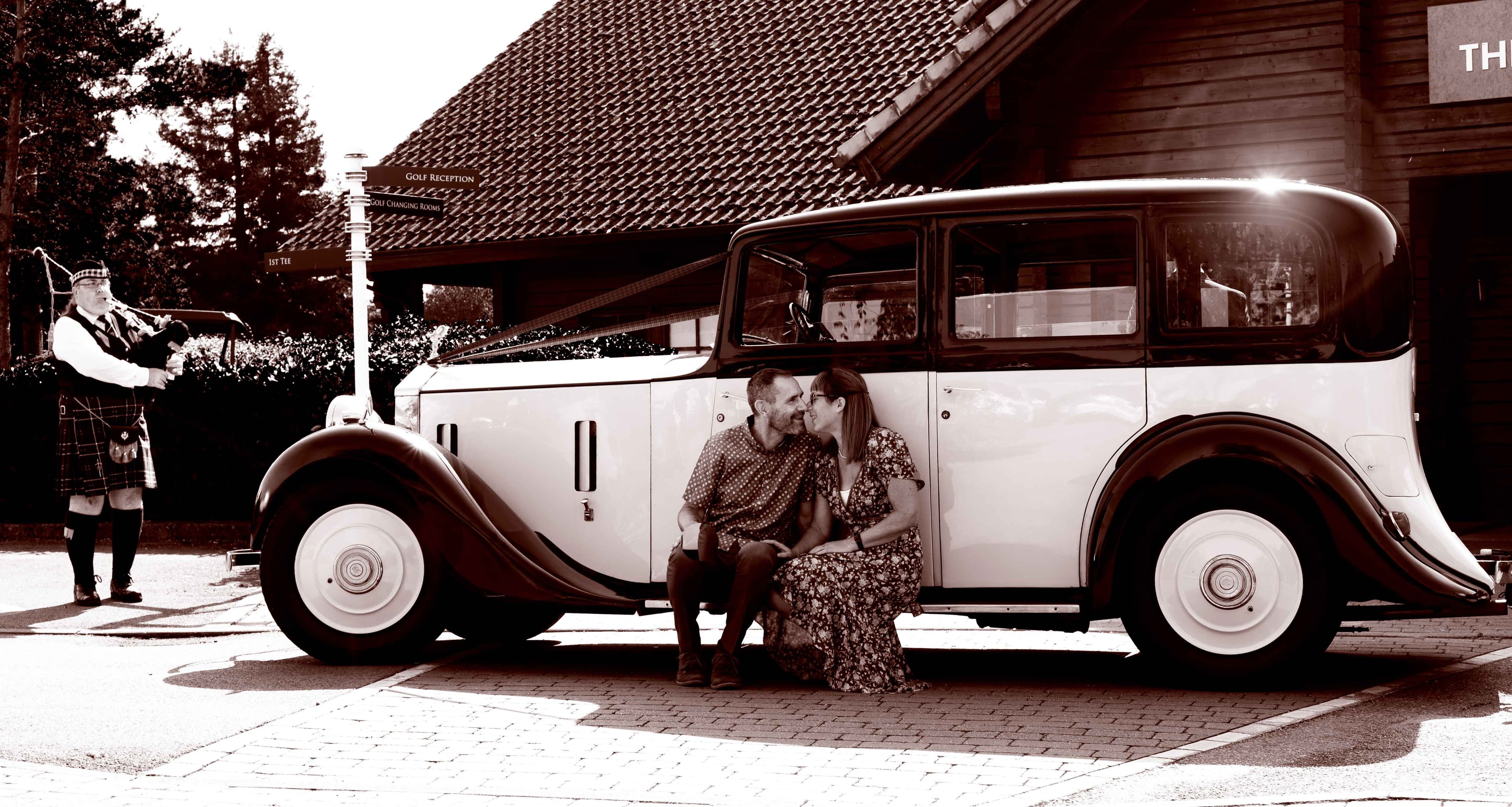 Couple kissing in front of a vintage Rolls-Royce