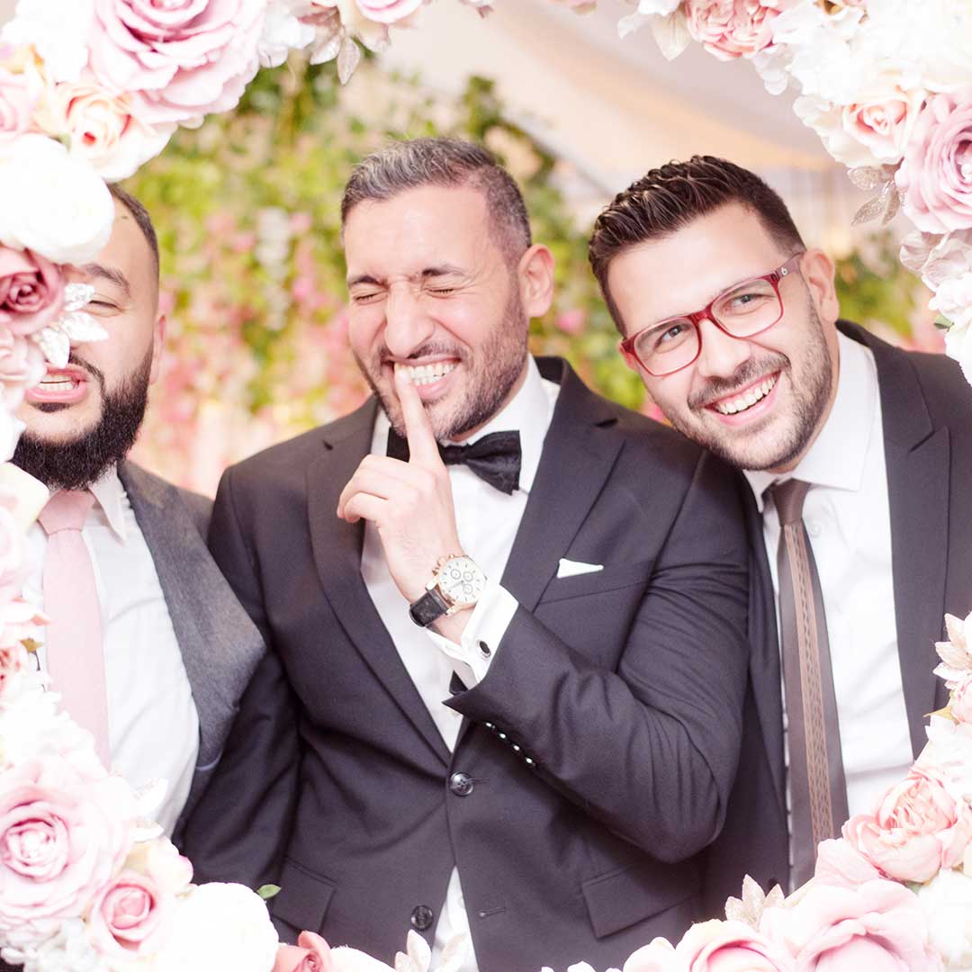 Groom shushing playful groomsmen