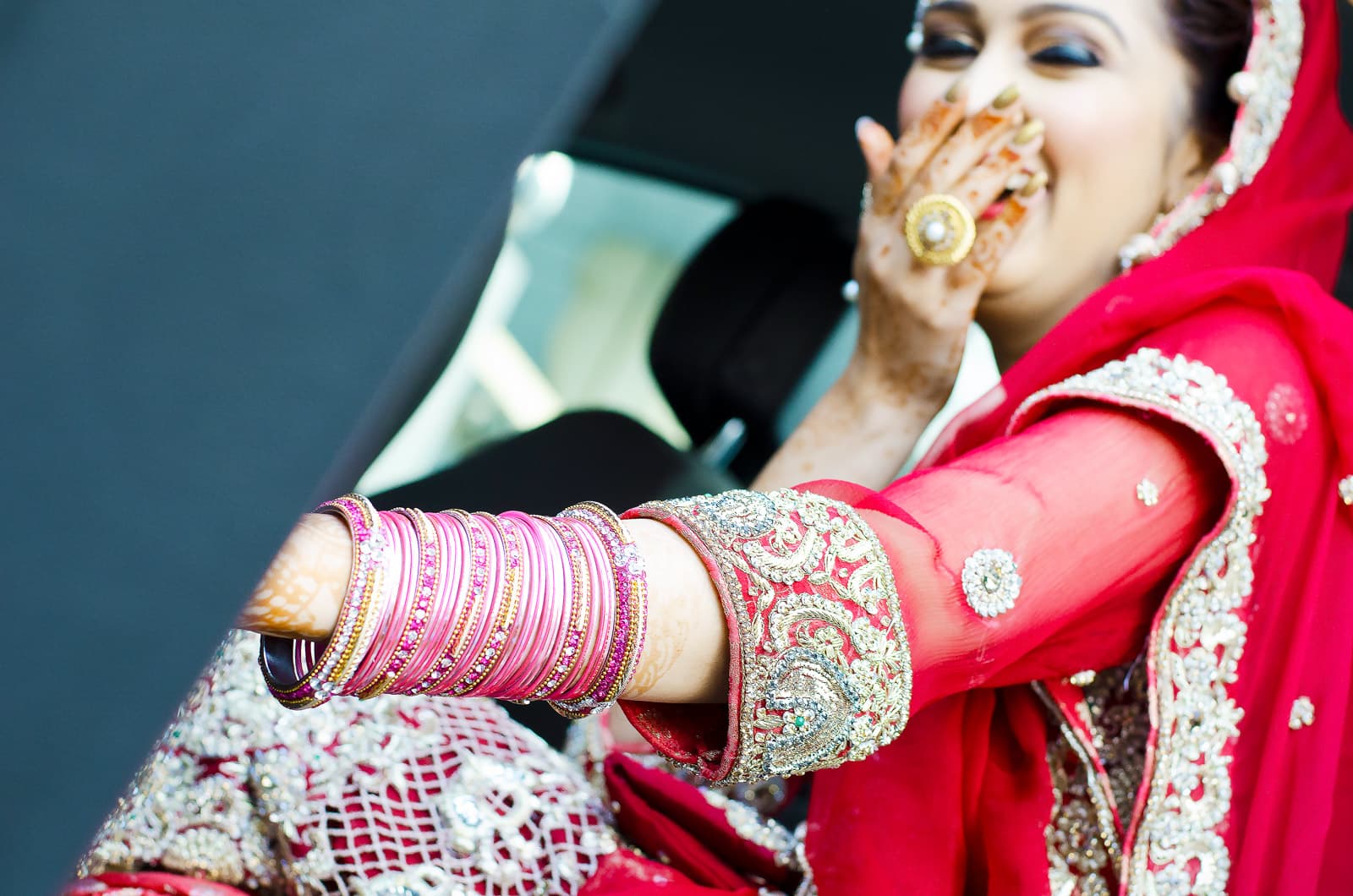 Laughing bride exiting car, overflowing with joy