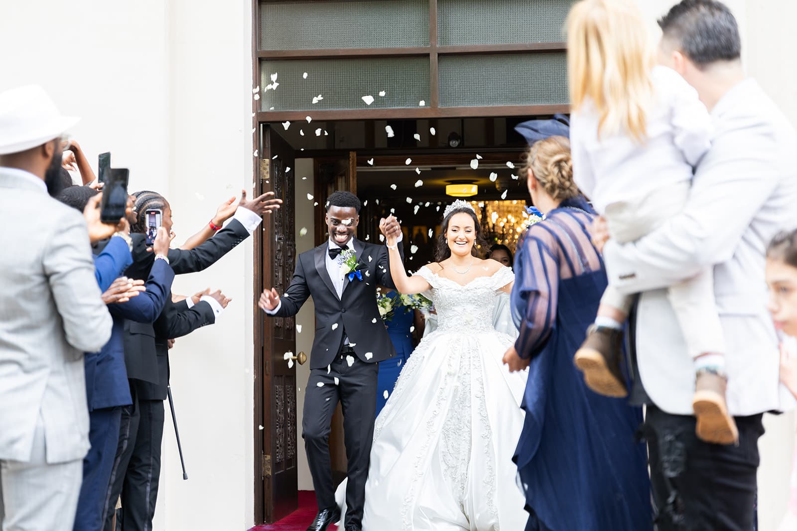 The bride and groom walk out of the church newly married